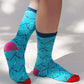 Light blue of TABBISOCKS brand Replant Pairs PDX Carpet Socks, male leg wearing socks with PDX Carpet design all over, with red toe, navy blue footwear and pink point color at the heel