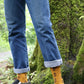 TABBISOCKS brand Replant Pairs Tree Socks in Mustard color with Grey color at the cuff and toe for the insert color, and a woman in jeans wearing socks with a brown tree design overall standing in the forest