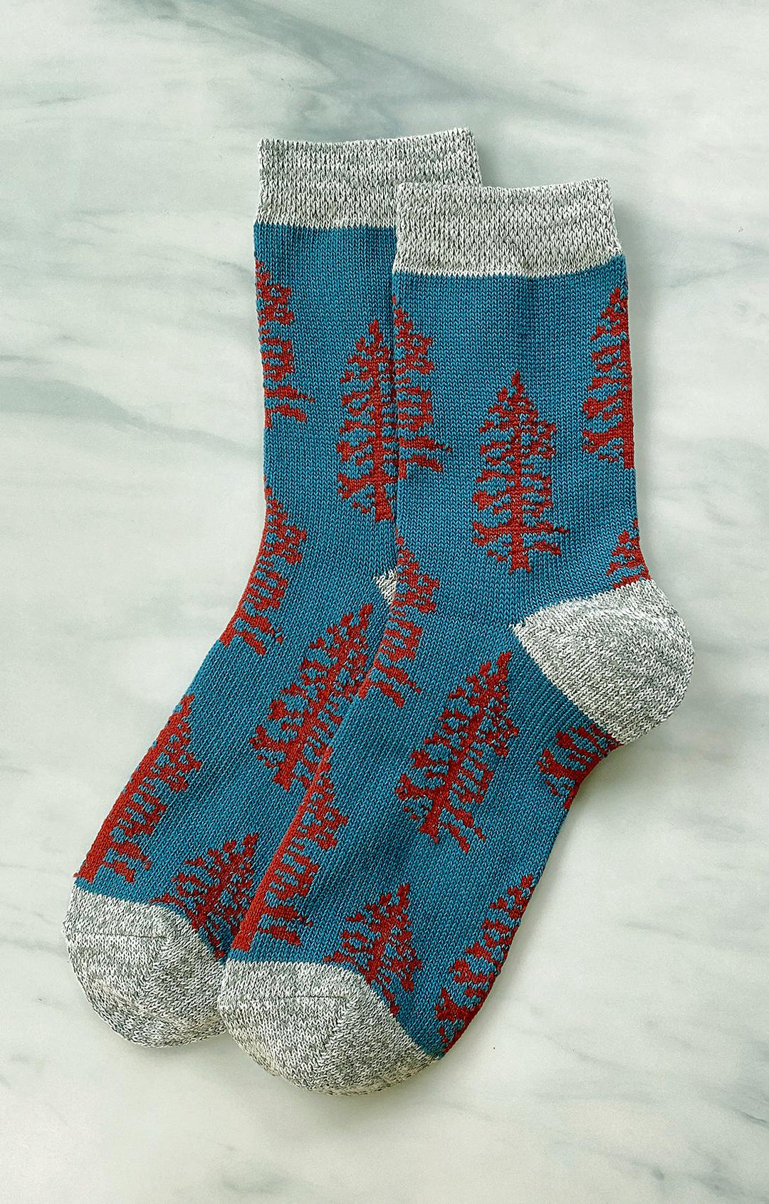 TABBISOCKS brand Replant Pairs Tree Socks in Teal color with Grey color at the cuff and toe and reddish brown tree design all over the socks.