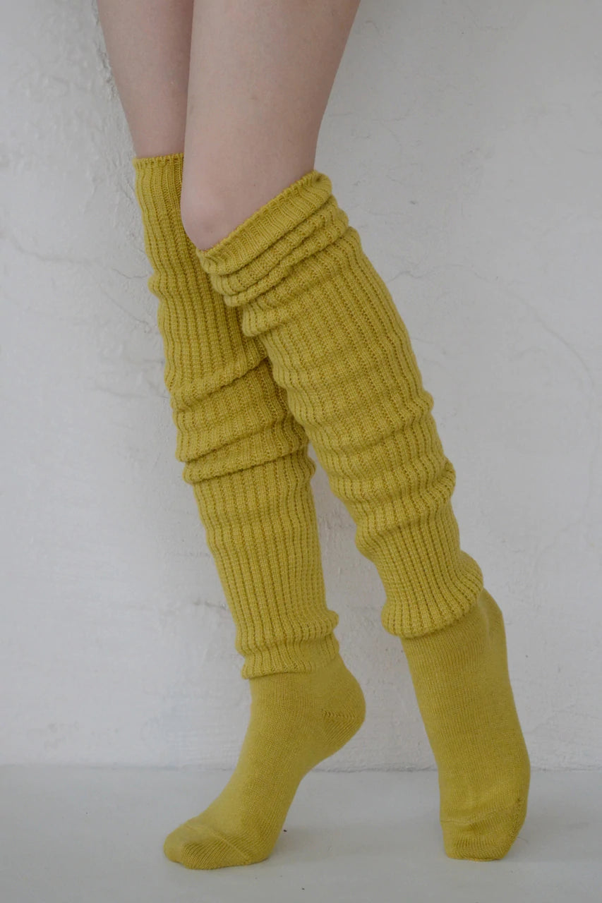 Female leg wearing TABBISOCKS brand Scrunchy Over the Knee Socks, knee-length knee socks in Bitter Yellow color