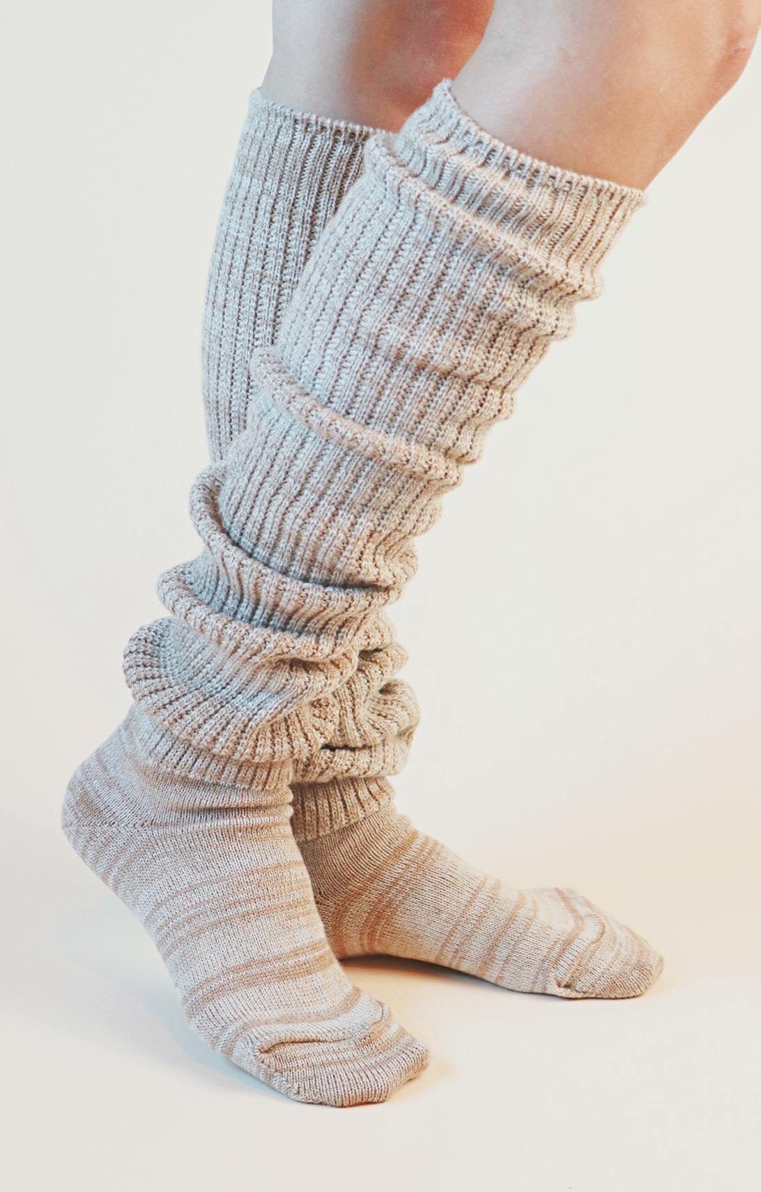 Side view of a woman's leg wearing TABBISOCKS brand Scrunchy Over the Knee Socks, knee-length knee socks in Ivory Beige