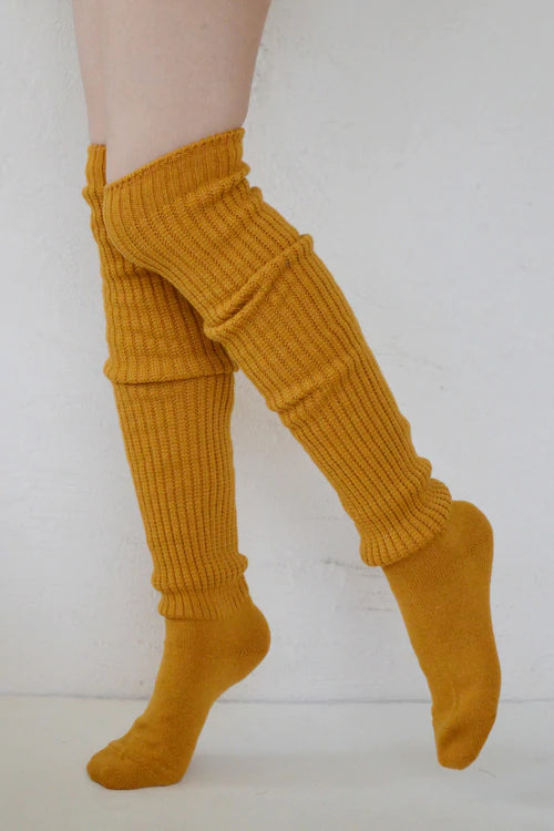 Female leg wearing TABBISOCKS brand Scrunchy Over the Knee Socks, knee-length knee socks in Mustard color