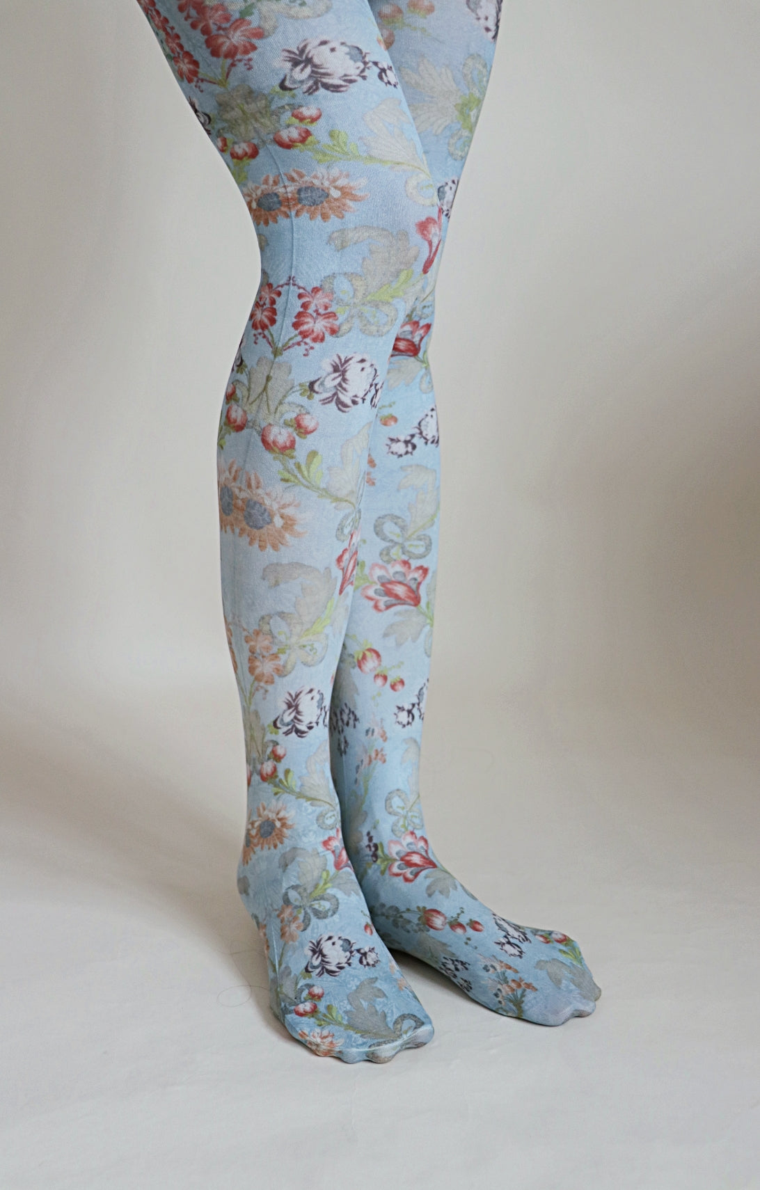 Overall light blue-ish fabric with floral patterns throughout the tights.