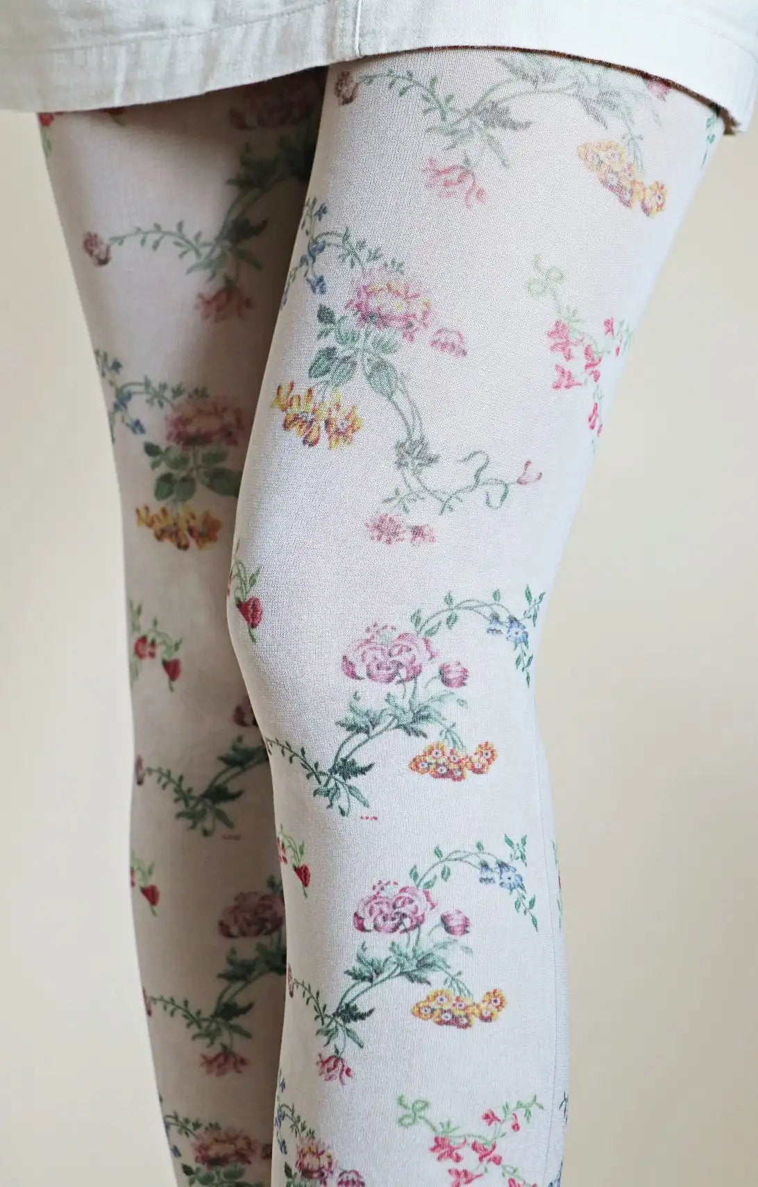 Overall whitish fabric with a small floral pattern throughout the tights.