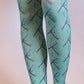 Female leg wearing TABBISOCKS brand PDX Carpet Patterned Tights, emerald green in color with an overall PDX Carpet pattern
