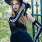 Woman in a witch Halloween costume wearing TABBISOCKS brand Skeleton Arm Warmers Long with white bone print on black fabric.