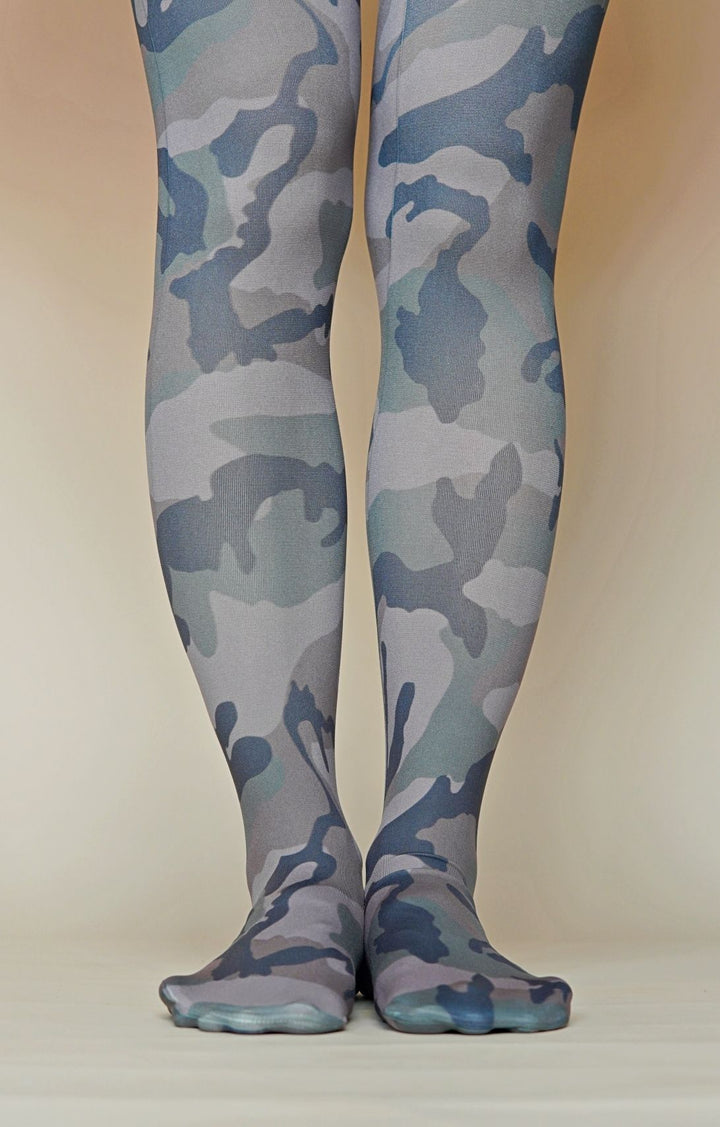 A pair of camouflage printed tights worn on a model, with the pattern visible on the legs and feet.