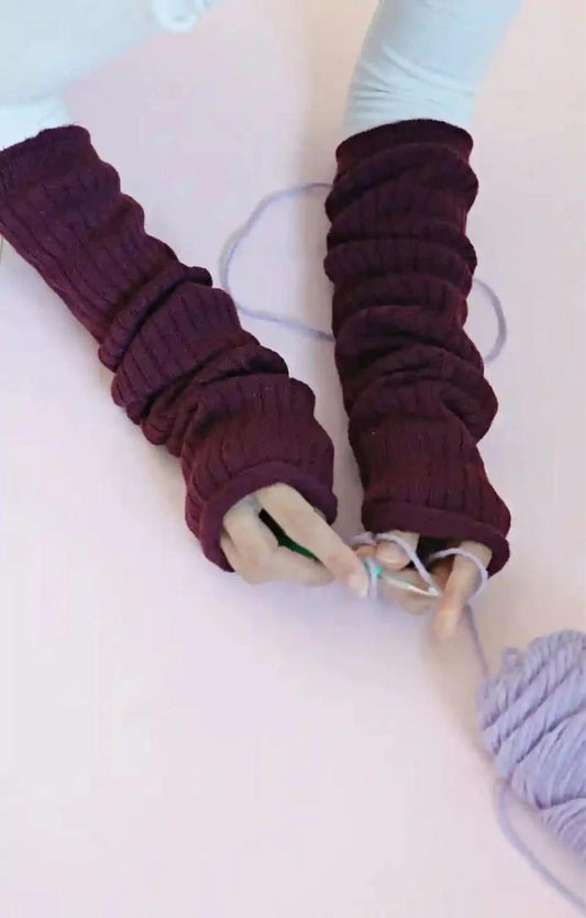 Woman's arm knitting in a white cut sleeve wearing maroon color of TABBISOCKS brand Wool Blend Leg and Arm Warmers