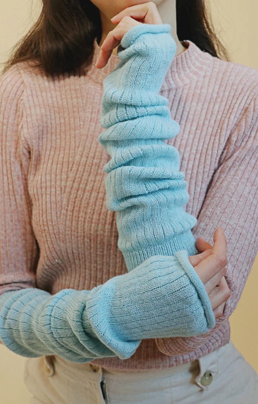 Arm of a woman wearing an ivory-colored sweater wearing the Powder Blue color of a product called Wool Blend Leg and Arm Warmers of the TABBISOCKS brand