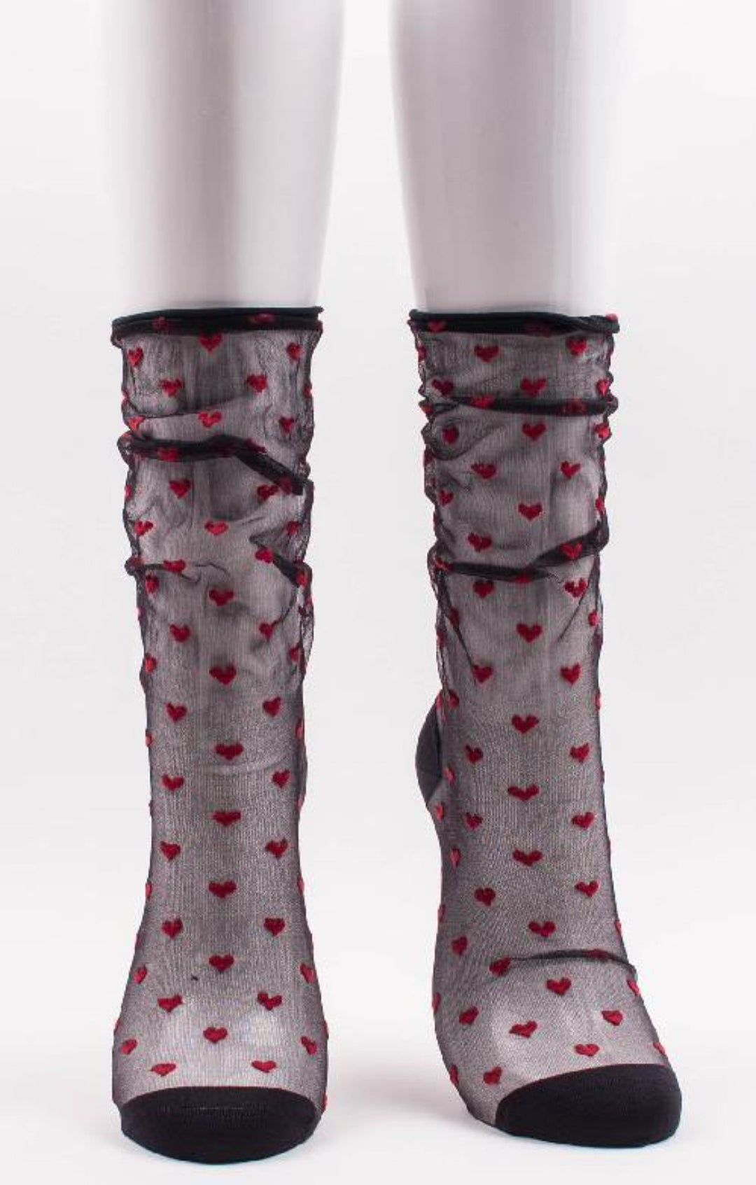 Red heart patterns on black transparent crew socks.