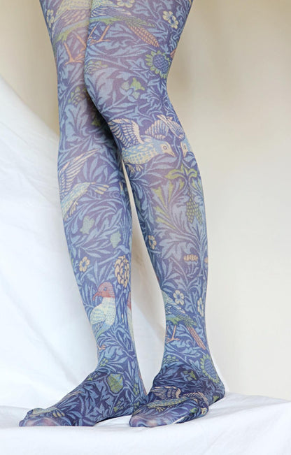 TABBISOCKS brand William Morris collection tights called Bird, with an overall design of birds and plants, in an antique blue-purple color.