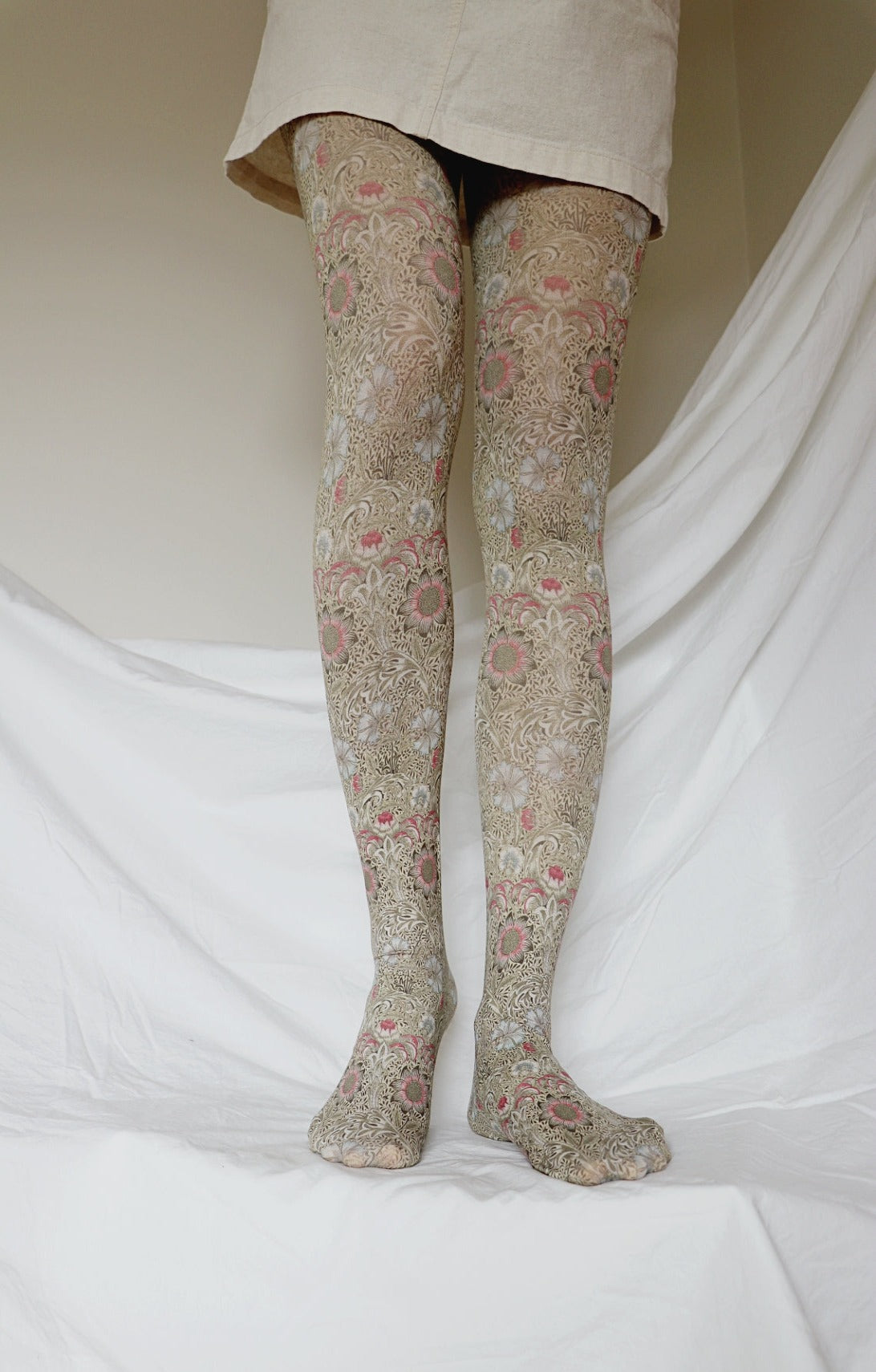 TABBISOCKS brand William Morris collection Corn Cockle tights with an overall floral design and a dull yellow-greenish color