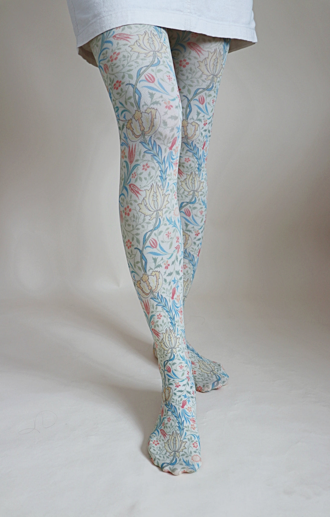 Tights called Flora from the William Morris collection of the TABBISOCKS brand, with a unique red and yellow plant pattern throughout, in antique-looking light blue and white colors