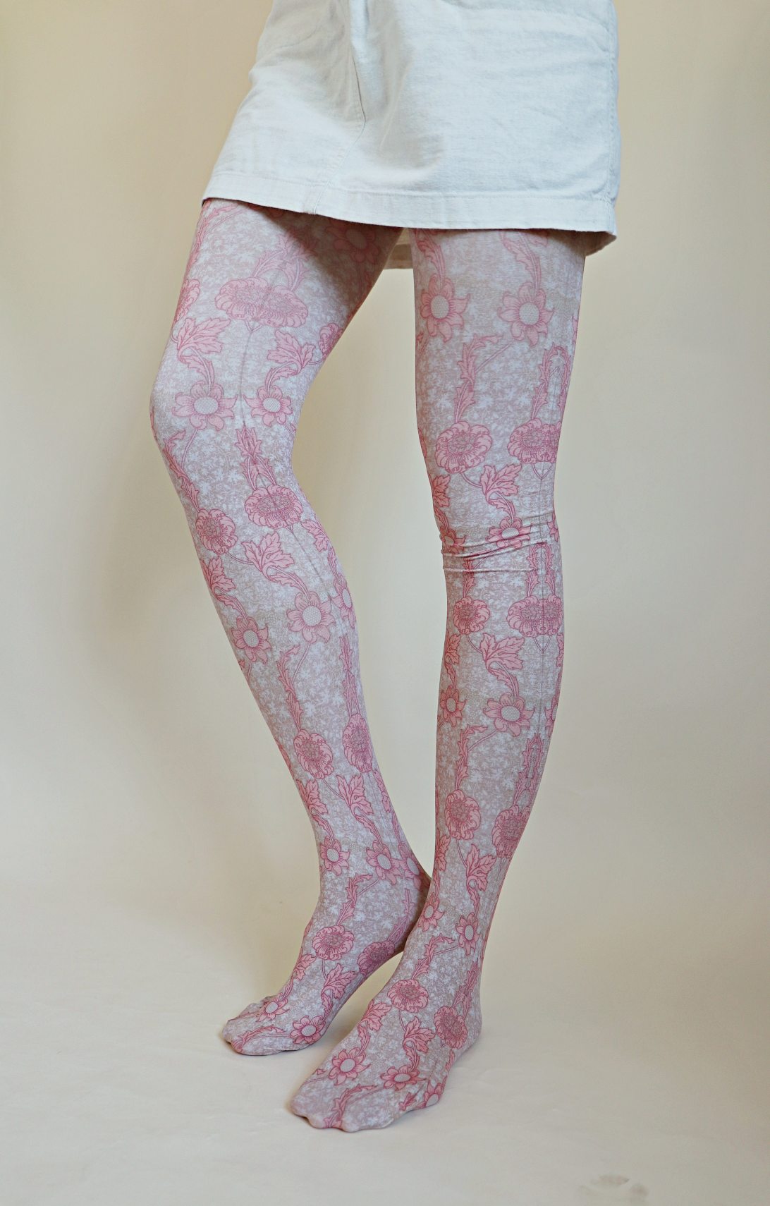 Tights called Kennet from the William Morris collection of the TABBISOCKS brand, with a pink floral design throughout, in an antique-like peach color