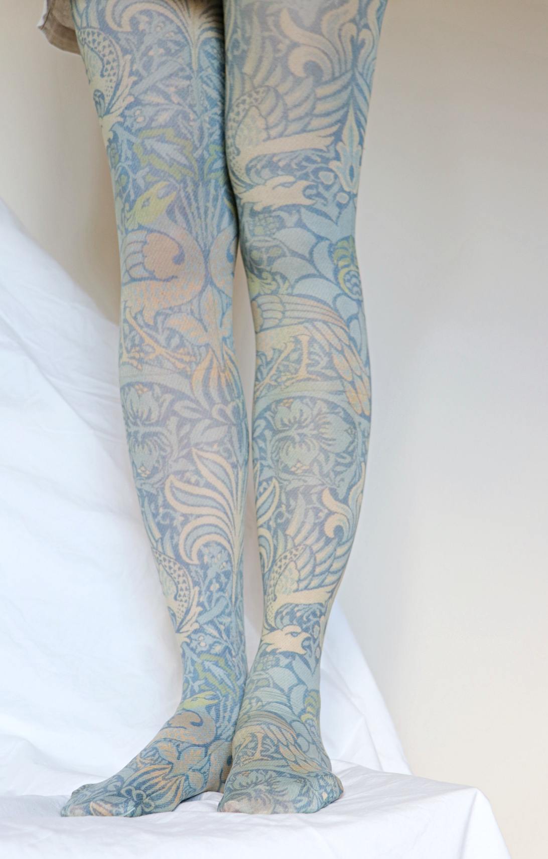 Peacock & Dragon tights from the William Morris collection of the TABBISOCKS brand, with an overall design of peacocks, dragons and plants in an antique blue color